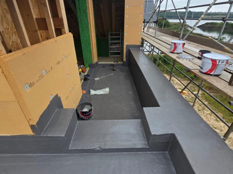 The waterproofing extends up vertical surfaces. In this case, it will be covered when cladding is applied.