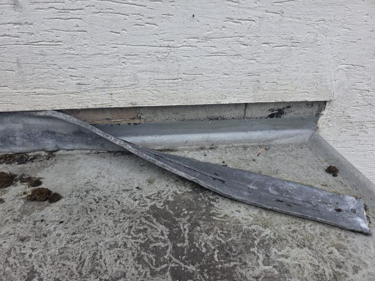Lead flashing was easily peeled away, indicating poor adhesion