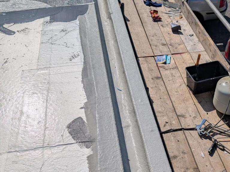 The undercoat being installed, paying particular attention to edges