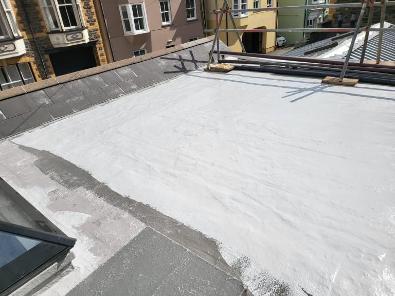 The topcoat is applied in areas, working quickly but carefully to avoid creating seams