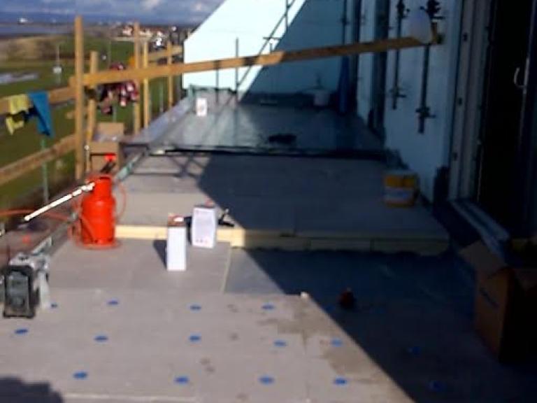 A lower balcony receives its waterproofing