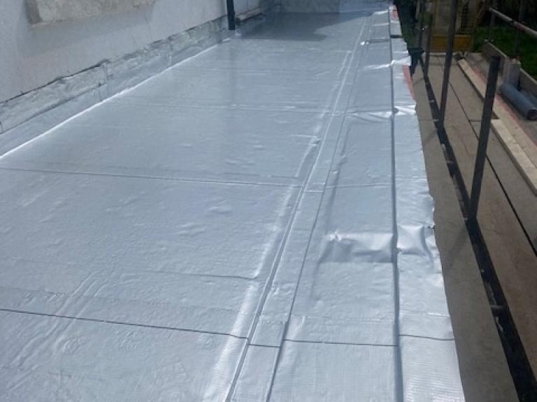 Along its entire length (rather than in sections)