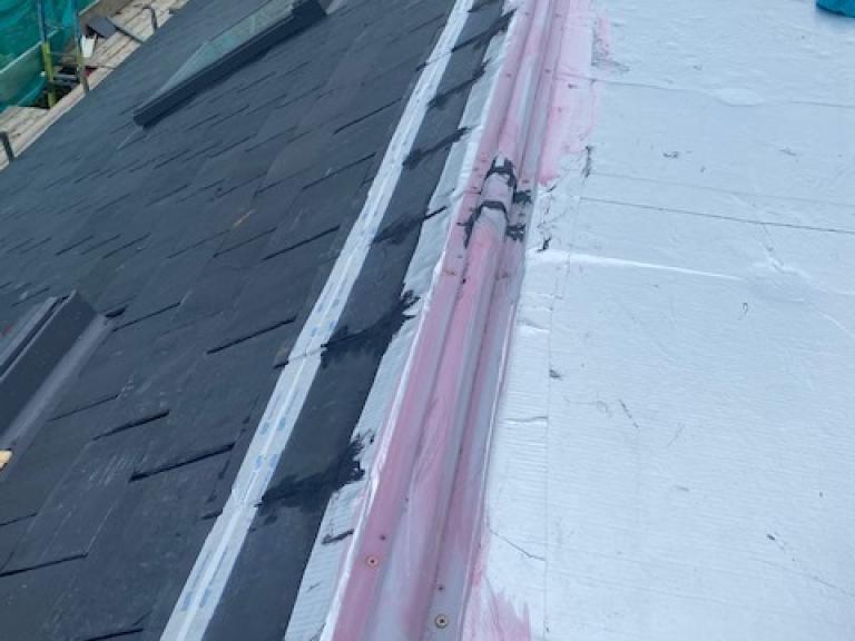 Installing the polymer flat roof jointlessly and seamlessly against lipped ridge
