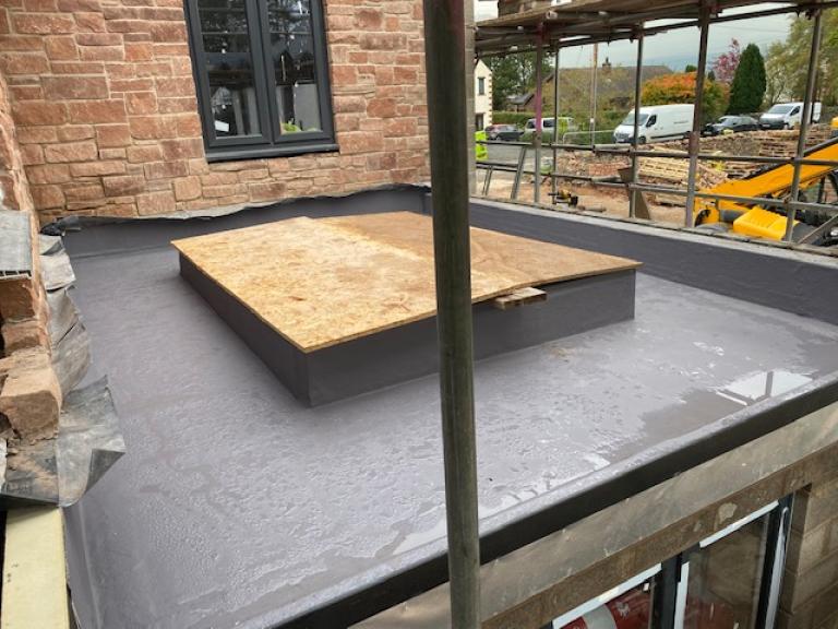 A gentle gradient carries all water away from both the skylight and the adjoining wall